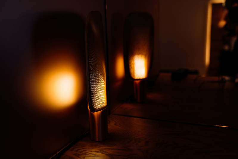 Hand holding LED tape light near cove mounting bracket during residential installation